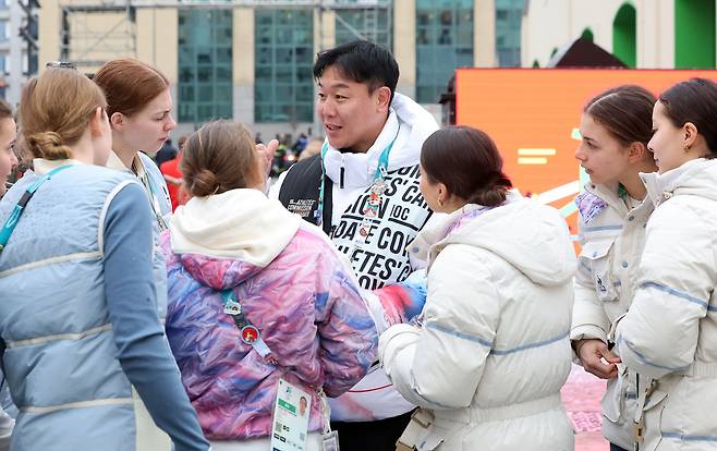 밀라노 올림픽 빌리지에서 만난 외국인 선수들과 대화를 나누는 원윤종(가운데). 뉴스1