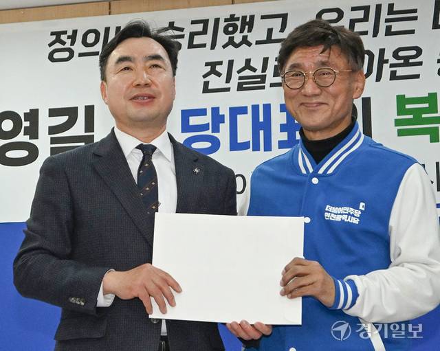 윤관석 민주당 전 의원이 20일 인천시당을 찾아 고남석 시당위원장에게 복당 신청서를 건네며 기념촬영 하고있다. 조병석기자