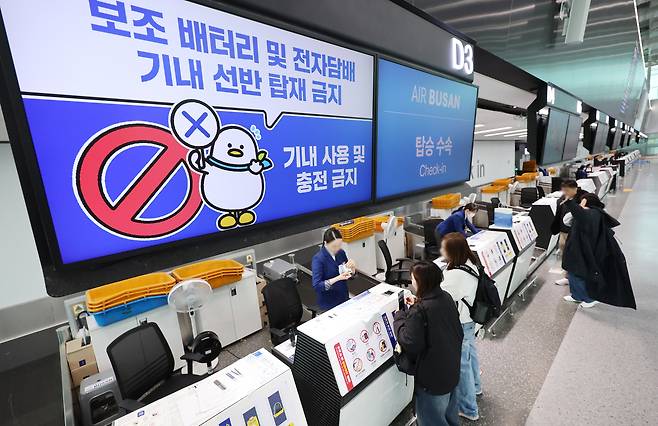 대한항공 등 한진그룹 소속 5개 항공사의 보조배터리 기내 사용 금지 시행일인 지난달 26일 부산 강서구 김해국제공항 에어부산 탑승 수속 카운터에 보조배터리 기내 사용 및 충전 금지 안내문이 뜨고 있다. [연합]