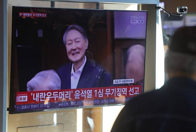 19일 서울역 대합실에서 시민들이 12·3 비상계엄 관련 내란 우두머리 혐의로 기소된 윤석열 전 대통령에 대한 1심 선고공판 TV 생중계를 시청하고 있다.  [연합]