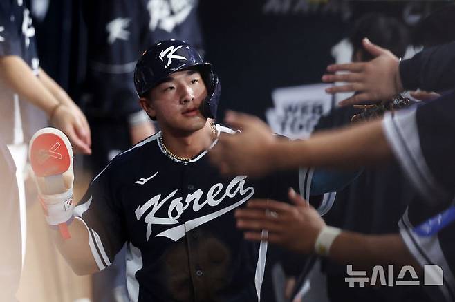 한국 3회초 공격 1사 주자 2, 3루서 문보경의 내야 땅볼 때 3루 주자 안현민이 홈인한 뒤 더그아웃에서 동료들과 하이파이브하고 있다.
