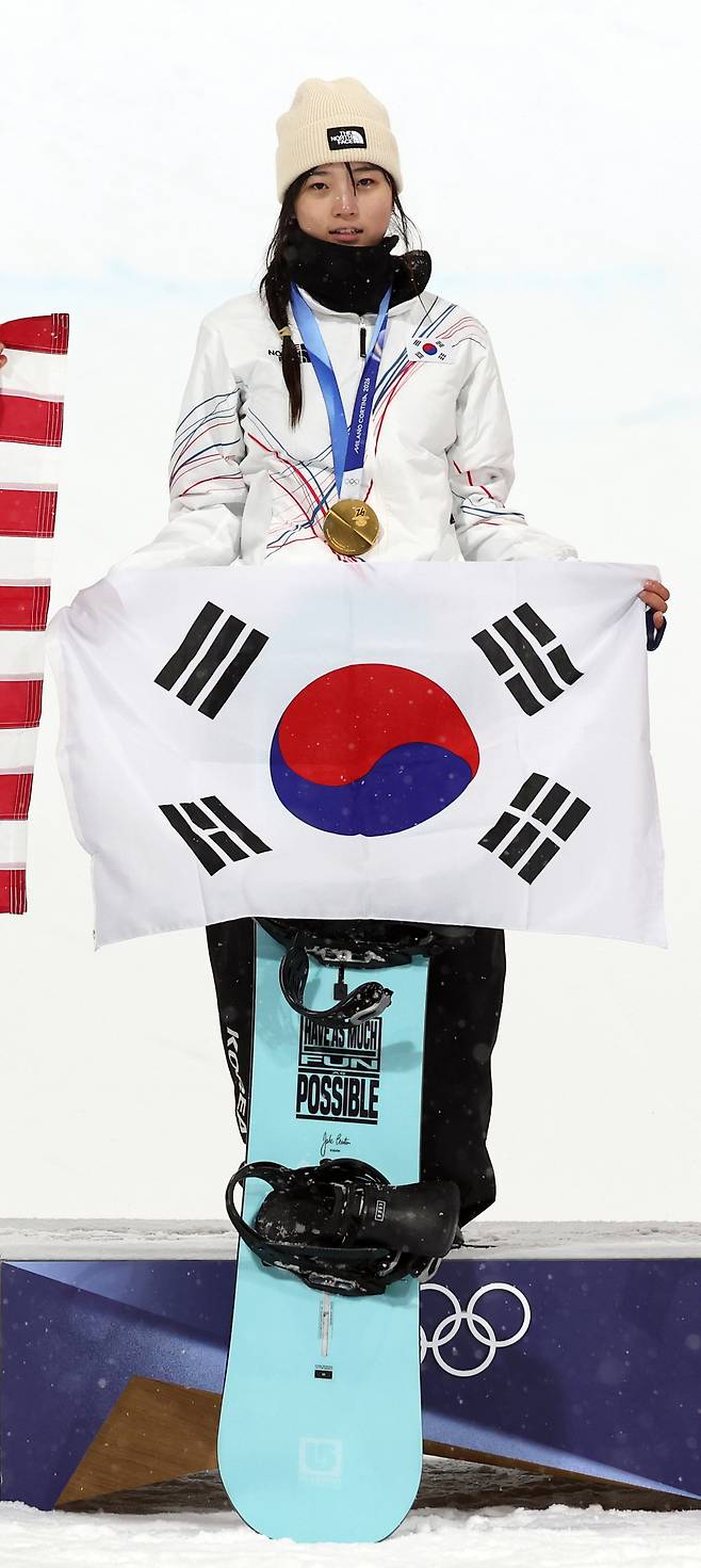 지난 12일 스키 스노보드 여자 하프파이프 금메달을 따낸 최가온이 사싱식에서 태극기를 들어보이고 있다. 연합뉴스