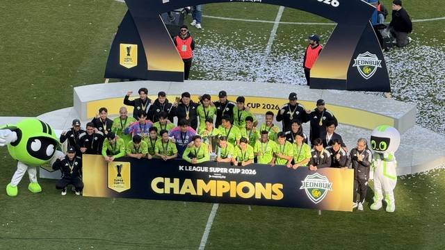 전북현대모터스FC가 21일 전주월드컵경기장에서 열린 쿠팡플레이 K리그 슈퍼컵 2026에서 우승컵을 들어올린 뒤 인증 사진을 찍고 있다. 박현우 기자