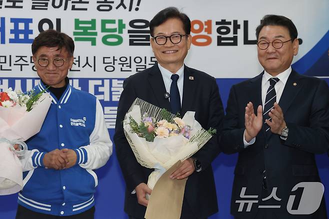 송영길 전 더불어민주당 대표가 지난 20일 오후 인천 남동구 더불어민주당 인천시당을 찾아 복당 신청서를 제출한뒤 지지자들로부터 꽃다발을 전달받고 있다. 검찰은 이날 밤 송 전 대표에 대한 상고포기를 결정, 송 전 대표는 무죄를 확정받았다 . 2026.2.20 ⓒ 뉴스1 이광호 기자