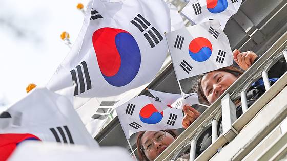 2024년 2월 27일 대구 달서구 월성코오롱하늘채 1단지 아파트에서 입주민들이 228 민주운동 기념일과 3.1절을 맞아 태극기를 달고, 손에 든 태극기를 흔들고 있다. 뉴시스