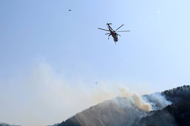 8일 경북 경주시 문무대왕면 입천리 일대에서 산불이 번지자 헬기가 불을 끄고 있다.[연합]