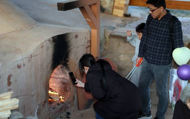 지난 21일 강진청자축제장은 찾은 한 가족이 화목가마에서 불을 지피며 가족의 안녕을 기원하고 있다. 강진군 제공
