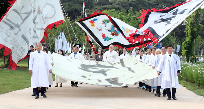 제56회 동학농민혁명기념제가 11일 전북 정읍 동학농민혁명기념공원에서 ‘피어나는 녹두꽃, 자라나는 평화’를 주제로 열린 가운데, 흰 도포를 입은 참가자들이 대형 깃발을 앞세워 행진하고 있다. 정읍시 제공