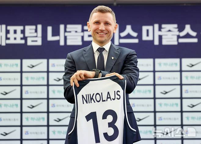 [서울=뉴시스]    Reporter Kim Jin-ah = National men's basketball team coach Nikolajs Mazurs is taking a commemorative photo with his uniform at the inauguration press conference held at the Press Center in Jung-gu, Seoul on the 16th. 2025.01.16. bluesoda@newsis.com