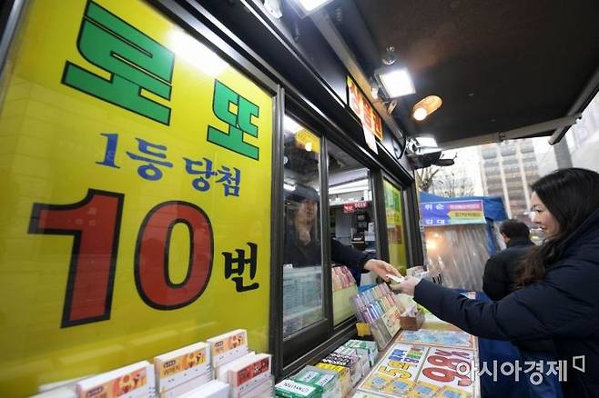 한 시민이 밝은 표정으로 로또를 구매하고 있다. 아시아경제DB