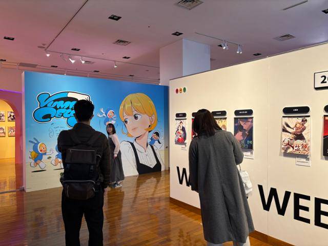 관람객들이 21일 일본 도쿄 한국문화원에서 한국콘텐츠진흥원 개최로 열린 '2026 K-웹툰 전시회'에서 웹툰 '유미의 세포들' 그림을 배경으로 사진을 촬영하고 있다. 도쿄=류호 특파원