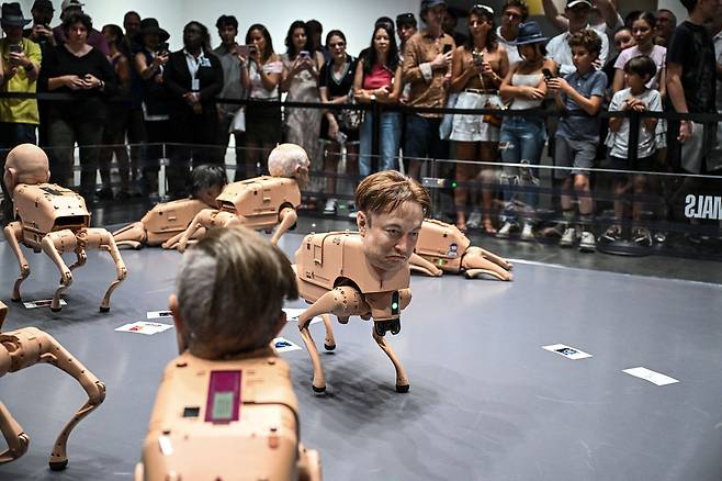 지난해 말 아트바젤 마이애미에서 화제가 된 ‘레귤러 애니멀스’. 디지털 아티스트 비플의 작품으로 일론 머스크(아래), 저커버그 등의 얼굴을 한 로봇 개로 구성했다. [AFP=연합뉴스]