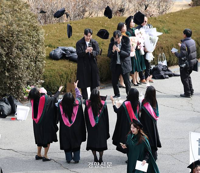 졸업생들이 학사모를 던지고 있다.