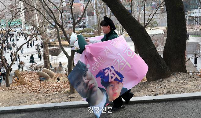 졸업생이 학우들이 만들어준 현수막을 몸에 두르고 있다.