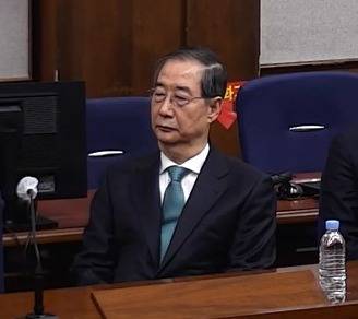 Former Prime Minister Han Duck-soo sits in the courtroom as he attends a sentencing hearing on charges of engaging in key insurrection duties at the Seoul Central District Court in Seocho District, southern Seoul, on Jan. 21. [NEWS1]