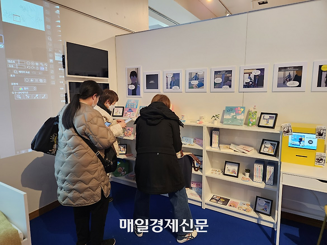 한국콘텐츠진흥원이 일본 도쿄 한국문화원에서 개최한 ‘2026 K-웹툰 전시’의 ‘유미의 세포들’ 전시 부스에서 관람객이 한국어판 웹툰 서적을 읽고 있다. [도쿄 이승훈 특파원]