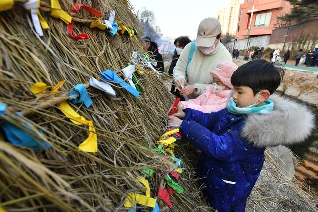 서울 노원구의 정월대보름 행사에서 어린이 등 주민들이 소원띠지를 새끼줄에 묶고 있다. 노원구청 제공