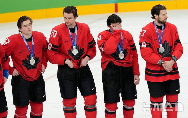 [밀라노=AP/뉴시스] 캐나다 아이스하키 남자 대표팀이 22일(현지 시간) 이탈리아 밀라노 산타줄리아 아레나에서 열린 2026 밀라노·코르티나담페초 동계올림픽 남자 아이스하키 결승전에서 미국에 패해 은메달을 목에 걸며 침울해 하고 있다. 2026.02.23.