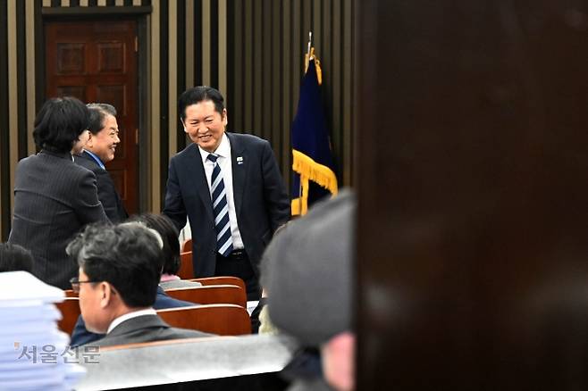 정청래(앞줄 오른쪽) 더불어민주당 대표가 22일 국회에서 열린 의원총회에서 의원들과 웃으며 인사를 하고 있다. 홍윤기 기자