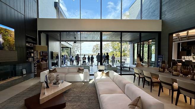 '더 뉴 아메리칸 홈(TNAH) 2026' 주방 거실 (올랜도=연합뉴스) 이지헌 특파원 = 지난 18일(현지시간) 방문한 미 플로리다주 올랜도시 인근 윈터파크의 '더 뉴 아메리칸 홈(TNAH) 2026' 거실 모습. 거실 밖에서 관람객들이 호수를 바라보고 있다. 2026.2.22 pan@yna.co.kr