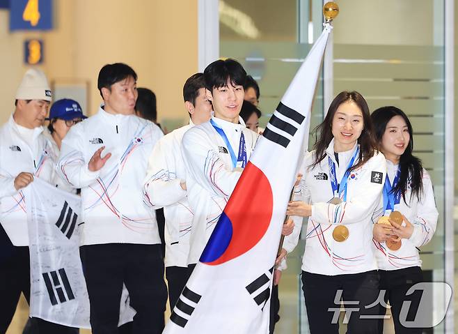 쇼트트랙 국가대표 최민정, 김길리, 황대헌을 비롯한 2026 밀라노·코르티나담페초 동계올림픽 선수단이 24일 인천국제공항을 통해 귀국하며 태극기를 흔들고 있다. 대한민국은2026 밀라노·코르티나담페초 동계올림픽에서 총 10개의 메달(금 3, 은 4, 동 3)과 종합순위 13위를 기록했다. 2026.2.24 ⓒ 뉴스1 이호윤　기자