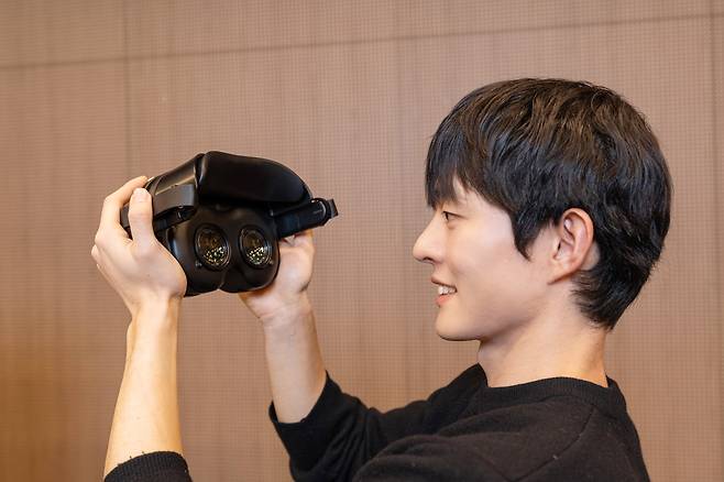 삼성디스플레이가 올해 초 열린 ‘CES 2026’에서 공개한 RGB 올레도스 헤드셋 데모 제품을 모델이 들어보이고 있다./삼성디스플레이