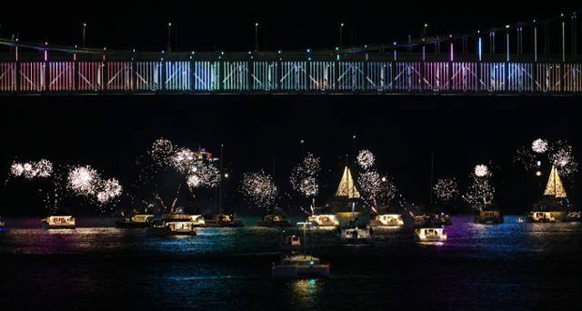 새해맞이 드론 특별공연을 앞두고 지난해 12월 31일 밤 부산 광안리 해변에서 투어 중인 요트에서 폭죽을 터뜨리고 있다. 최근 관광객과 젊은 층 중심으로 광안리의 야경과 폭죽, 드론쇼를 한꺼번에 즐길 수 있는 요트투어가 인기를 끌고 있다. 연합뉴스