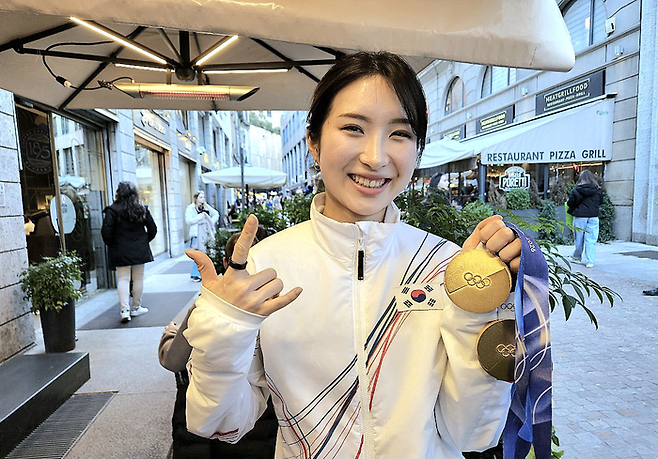 쇼트트랙 국가대표 김길리가 21일(한국시간) 이탈리아 밀라노 시내의 한 카페에서 매일경제와 단독인터뷰한 뒤, 자신이 따낸 금메달 2개를 들어보이면서 시그니처 포즈를 취하고 있다. 김길리는 “(포즈는) 내 느낌을 표현한 것”이라고 밝혔다. [밀라노 = 김지한 기자]