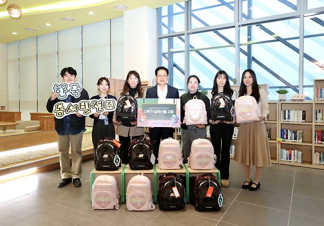 권명호 사장과 직원들이 새학기 책가방 꾸러미를 들고 기념사진을 찍고 있다. [한국동서발전]