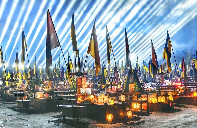 우크라이나 전쟁이 5년 차에 접어들기 하루 전인 23일(현지시간) 우크라이나 르비우의 리차키우 군인 묘지에서 '기억의 빛'으로 명명된 조명이 하늘을 비추고 있다. 유가족과 시민들은 촛불 추모 기도를 통해 전사자들을 기렸다.  EPA연합뉴스