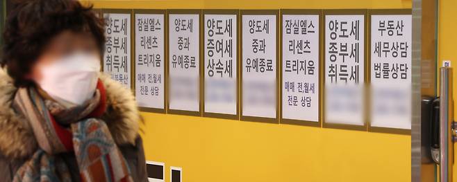 서울 잠실에 위치한 공인중개사 사무실 유리 벽에 부동산 관련 세금과 아파트 매매 물건 등의 안내문이 게시되어 있다.[연합]