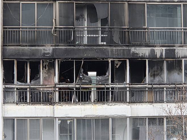 24일 오전 서울 강남구 대치동 은마아파트에서 발생한 화재로 검게 탄 8층 세대. 방충망이 녹아내려 넝마처럼 걸려있다. 이영기 기자.