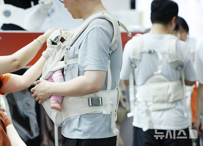 [서울=뉴시스] 김진아 기자 = 지난해 8월 14일 서울 강남구 코엑스에서 열린 제48회 베페 베이비페어에서 관람객들이 아기띠를 체험해보고 있다. 2025.08.14. bluesoda@newsis.com