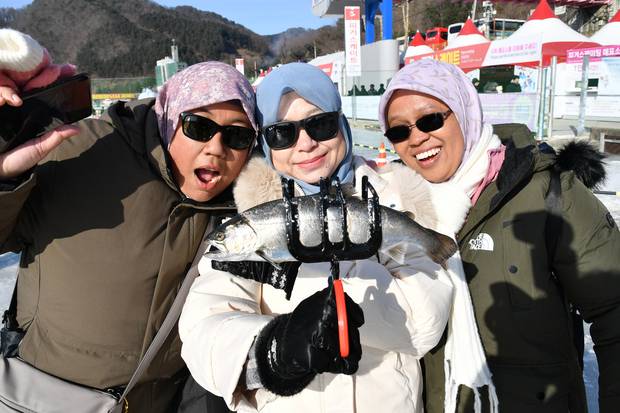 1일 ‘2026 얼음나라 산천어축제’가 열리는 강원 화천군 화천천 외국인 낚시터를 찾은 관광객이 낚아 올린 산천어를 들어보이고 있다. 연합뉴스