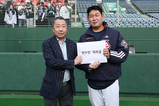 두산 구단주 박정원 두산그룹 회장이 25일 일본 미야자키 선마린 스타디움에서 주장 양의지(왼쪽)에게 선수단 격려금을 전달하고 있다. 사진 | 두산 베어스
