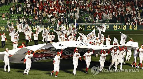 2010년 10월19일 대구 시민운동장에서 열린 2010 프로야구 한국시리즈 4차전 삼성 라이온즈-SK 와이번스 경기에서 SK 와이번스가 우승했다. 경기 직후 SK 와이번스 김성근 감독과 선수들이 팀 대형 깃발을 들고 그라운드를 돌고 있다. / 연합뉴스