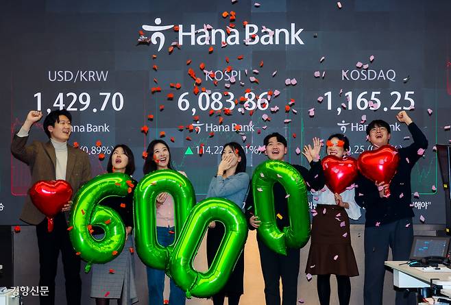 코스피, 자고 나면 ‘역대 최고’ 코스피가 사상 처음으로 6000선을 돌파한 25일 서울 중구 하나은행 본점 딜링룸 현황판 앞에서 직원들이 축하 행사를 하고 있다. 이날 코스피는 6083.86에 거래를 마감해 종가 기준 사상 최고치를 갈아치웠다.  이준헌 기자 heon@kyunghyang.com