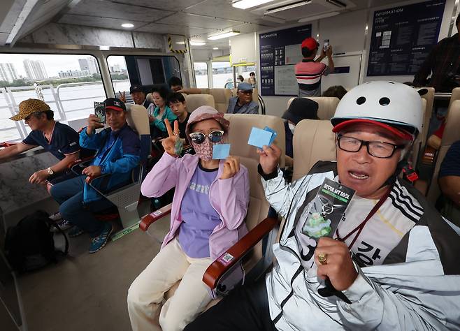 Passengers smile after boarding the Hangang Bus ferry on its opening day at Jamsil Pier in Songpa District, southern Seoul, on Sept. 18, 2025. [YONHAP]