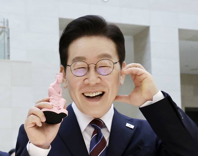 이재명 대통령이 26일 서울 용산구 국립중앙박물관에서 열린 특별전 '우리들의 이순신'을 관람한 뒤 상품관에서 기념품을 들고 포즈를 취하고 있다. 청와대통신사진기자단