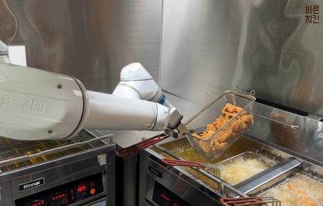 프랜차이즈 업계가 로봇 전문 기업과 손잡고, 푸드테크 투자를 늘리고 있다. 사진은 바른치킨 매장에 설치된 관절형 튀김 로봇. / 바른치킨