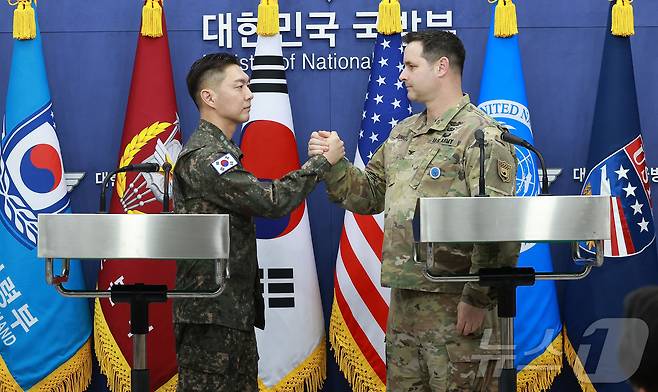 장도영 합동참모본부 공보실장과 라이언 도날드 주한미군사 공보실장이 25일 오후 서울 용산구 국방부에서 2026 자유의 방패(FS) 연습 계획을 발표한 후 손을 맞잡고 있다. 2026.2.25 ⓒ 뉴스1 사진공동취재단