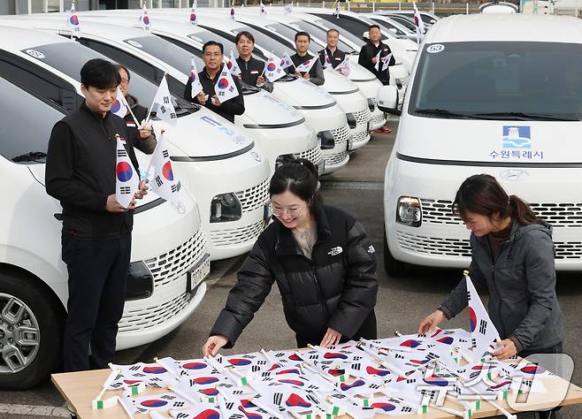 제107주년 3·1절을 사흘 앞둔 26일 경기 수원시 권선구 수원시교통약자지원센터 한아름콜에서 직원들이 3·1절을 맞아 교통약자지원차량에 부착할 태극기를 준비하고 있다. 2026.2.26 ⓒ 뉴스1 김영운 기자
