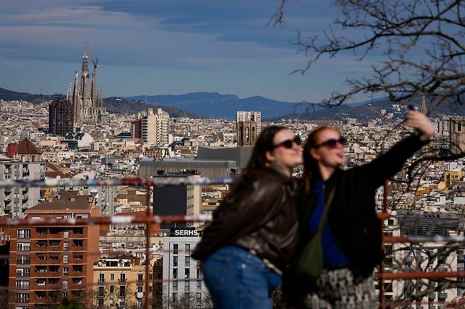 지난 20일(현지시간) 스페인 바르셀로나 사그라다 파밀리아 성당 앞에서 두 여성이 기념사진을 찍고 있다. 사그라다 파밀리아 성당의 예수 탑 십자가 상단 구조물이 설치되면서 성당은 최고 높이 172.5m에 도달했다. EPA=연합뉴스
