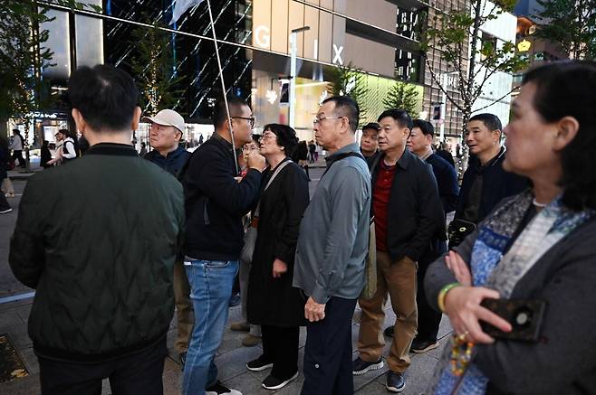 지난해 11월 일본 도쿄, 중국인 관광객들이 가이드의 설명을 듣고 있다. 사진=AFP(연합뉴스)