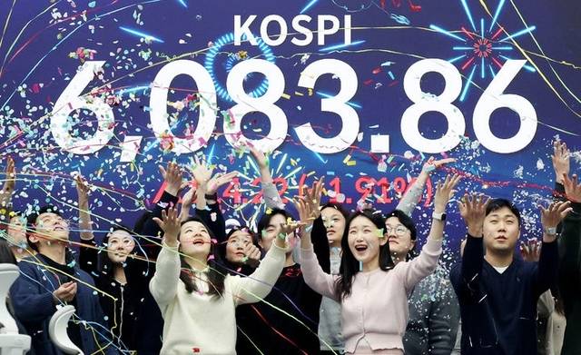 코스피가 사상 첫 6000을 돌파한 25일 서울 중구 우리은행 딜링룸에서 직원들이 축하 세리머니를 하고 있다. 뉴시스