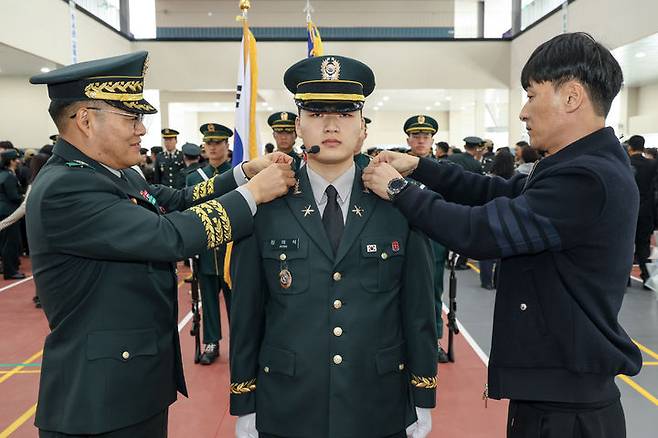 강관범 육군교육사령관(중장 강관범)과 가족이 정의석 하사에게 계급장을 수여하고 있다.(사진=육군부사관학교 제공) *재판매 및 DB 금지