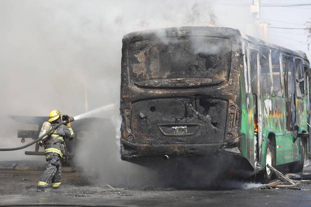 소방관이 22일(현지 시간) 멕시코 할리스코주 주도 과달라하라 일대에서 벌어진 소요 사태로 인해 불이 붙은 버스에 물을 뿌리고 있다. EPA연합뉴스