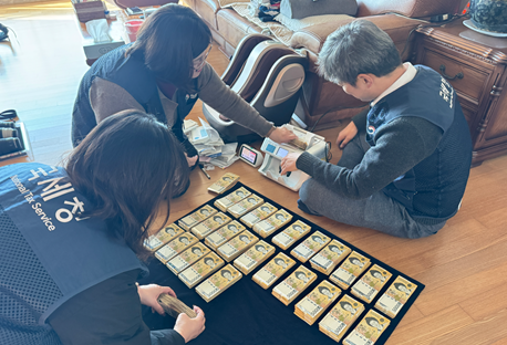 국세청이 26일 공개한 고액 체납자 대상 현장 수색 사진 중 하나로, 국세청 직원들이 한 고액 체납자의 집 화장실에서 5만원권으로 가득 찬 김치통을 발견해 현금을 계수하고 있다. ⓒ국세청 제공