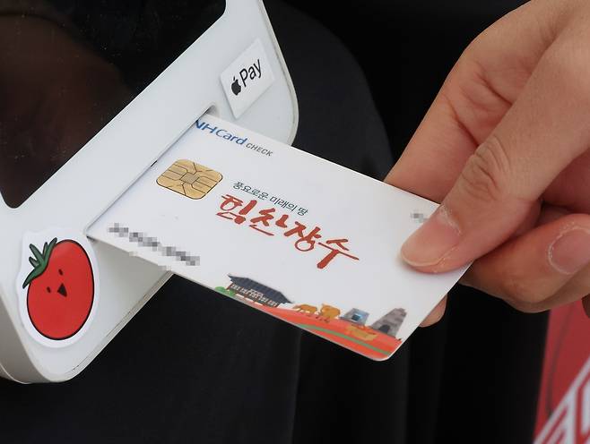 '월 15만원의 기쁨' (장수=연합뉴스) 나보배 기자 = 전북 장수군민에게 '농어촌 기본소득'이 처음 지급된 26일 장수군청 앞에서 진행된 상생소비 한마당에서 한 군민이 기본소득으로 물건을 구매하고 있다. 2026.2.26 warm@yna.co.kr