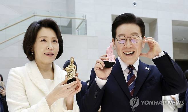 기념품 든 이재명 대통령 부부 (서울=연합뉴스) 김도훈 기자 = 이재명 대통령과 김혜경 여사가 26일 서울 용산구 국립중앙박물관에서 열린 특별전 '우리들의 이순신'을 관람한 뒤 상품관에서 기념품과 함께 기념촬영을 하고 있다. 2026.2.26 [청와대통신사진기자단] superdoo82@yna.co.kr